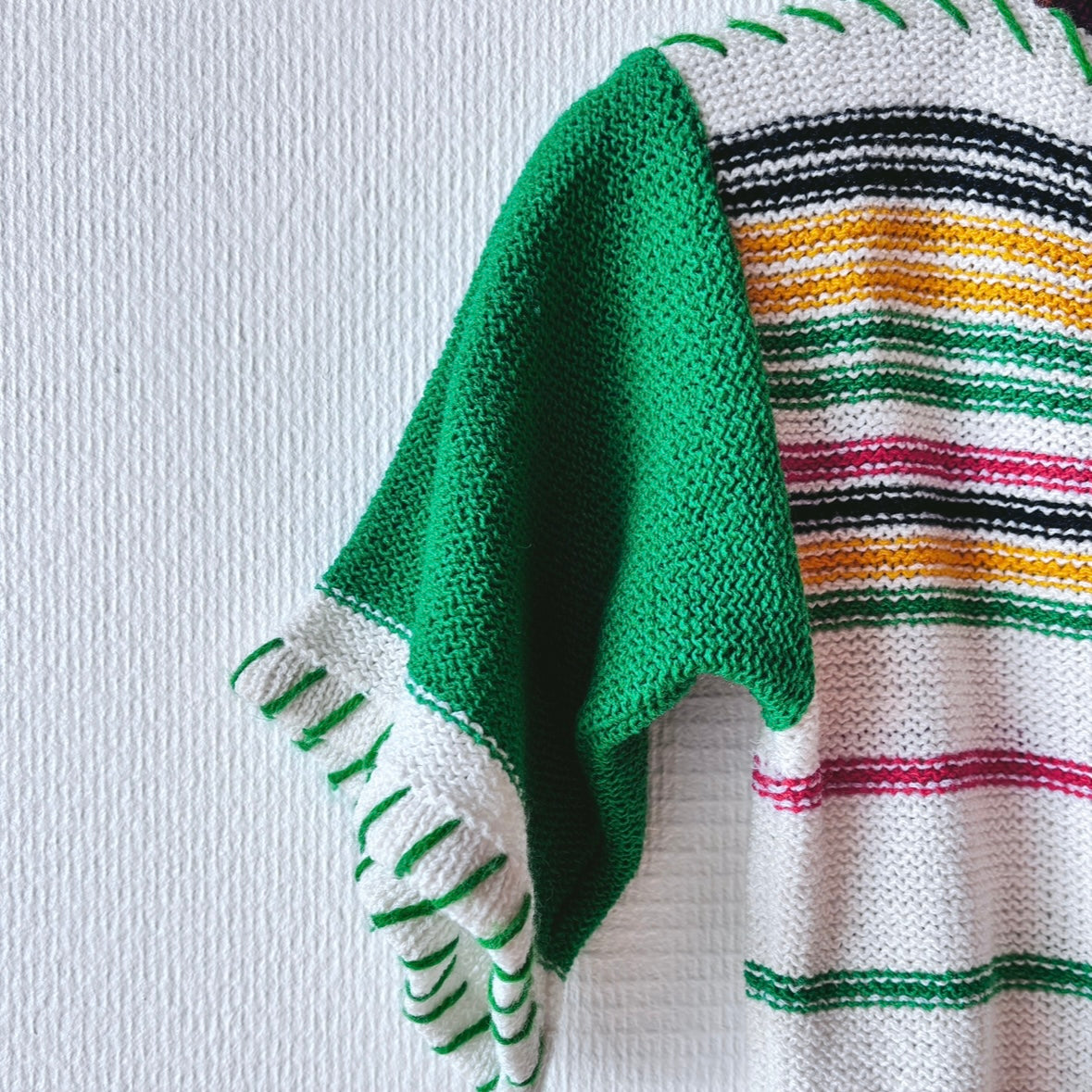 Close-up of the sleeve on the Chic Green Spring Sweater, highlighting knit texture