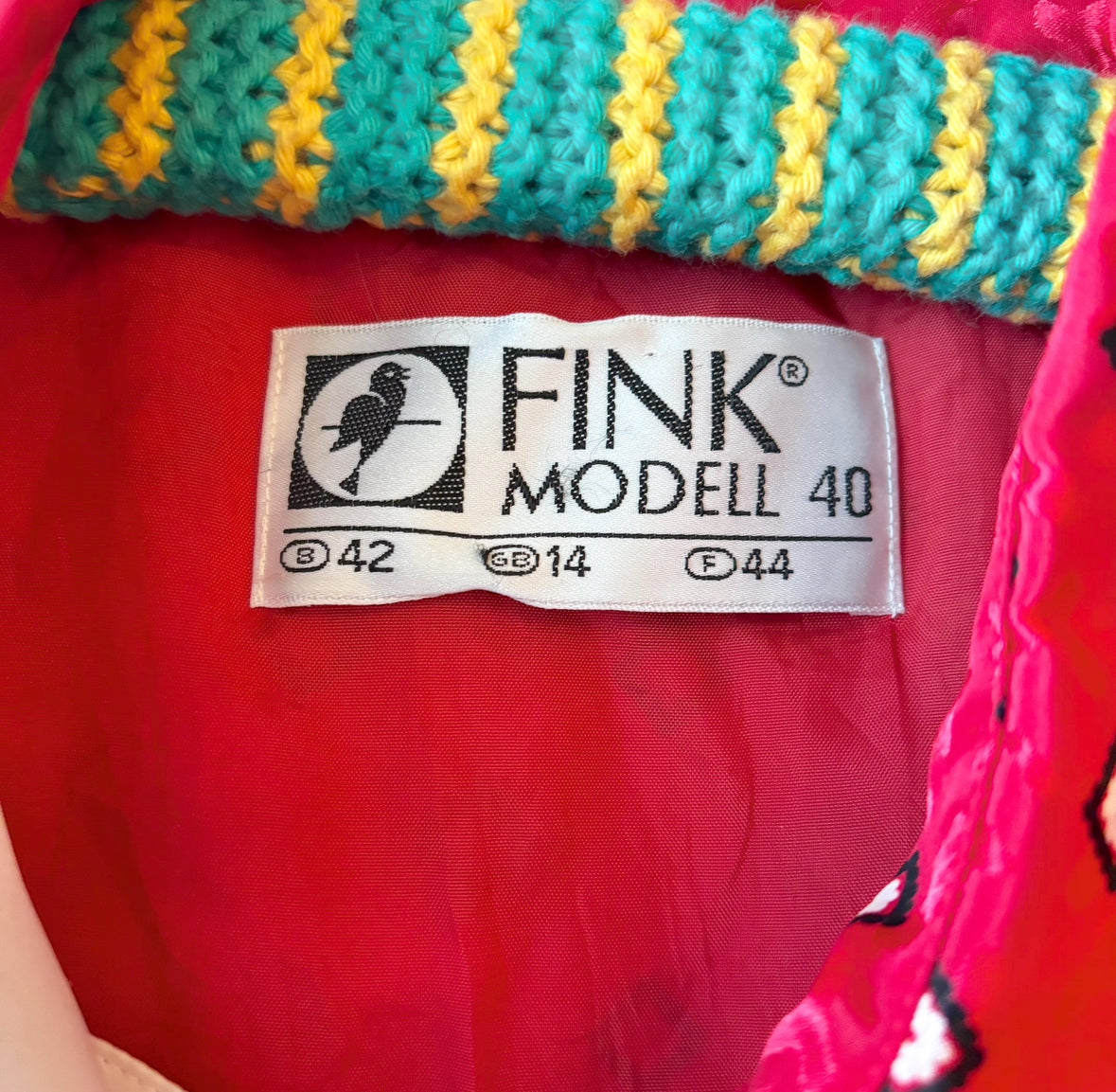 Close-up of the brand name called Fink Modell on the red dress