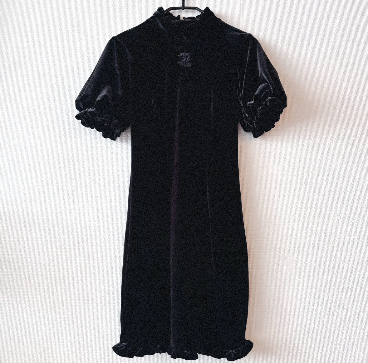 Black velvet chinese rose dress displayed on a hanger shwoing the full design