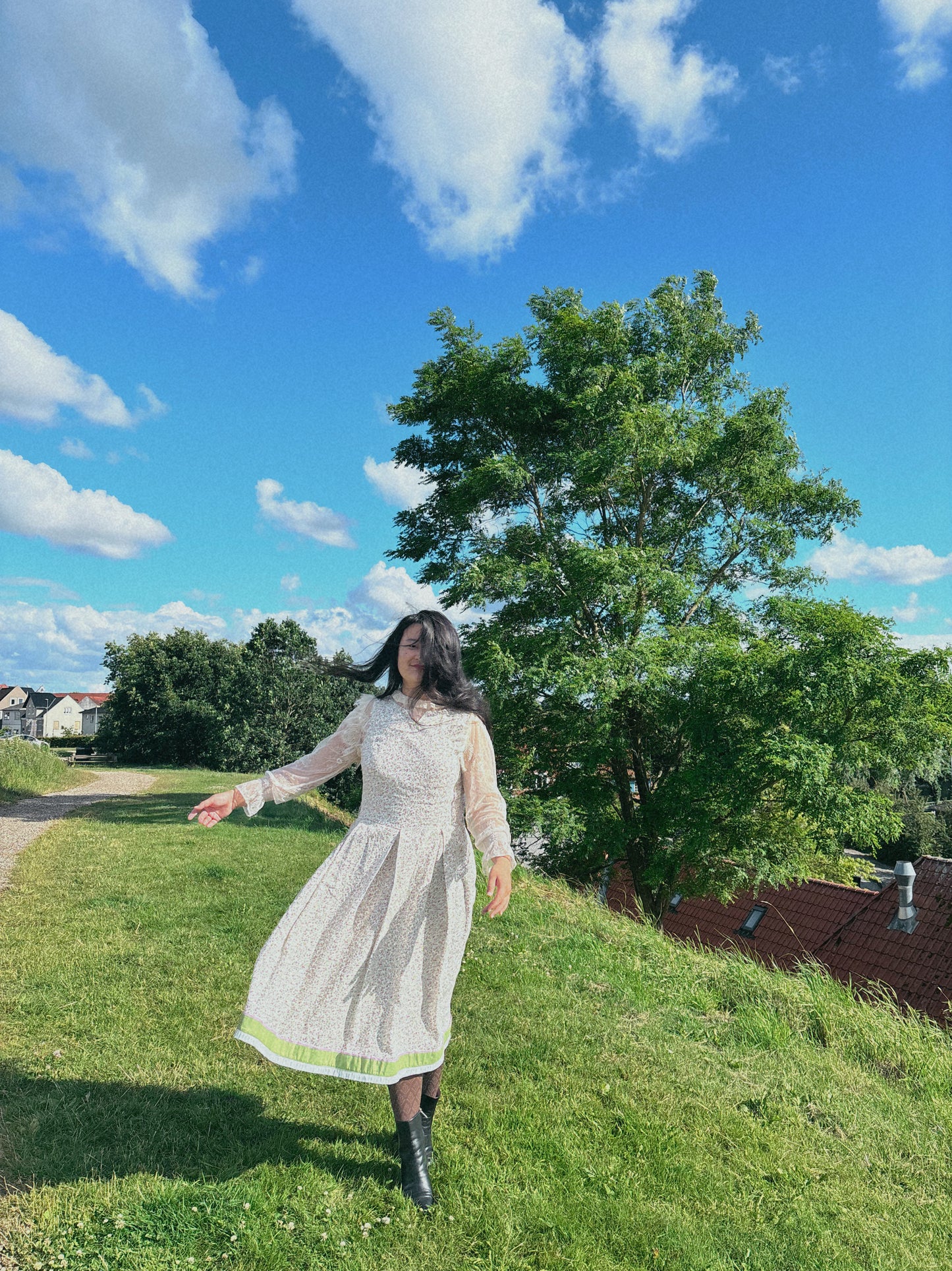 Model wearing floral folkcore dress with front to the camera, in outdoor setting