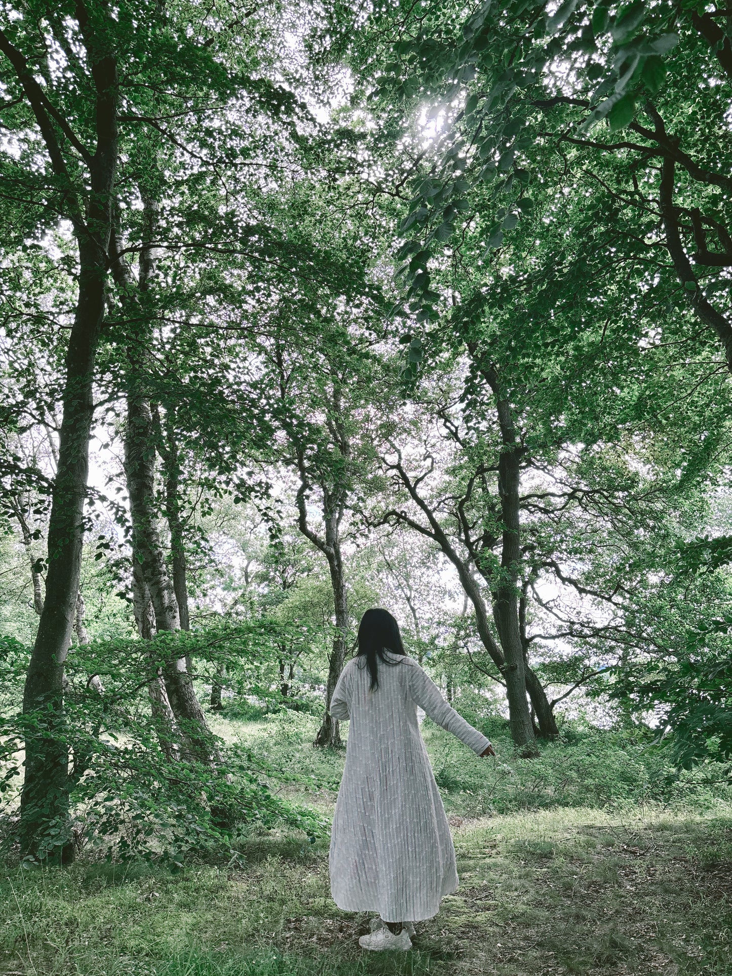 Model wearing secondhand white robe in an outdoor setting